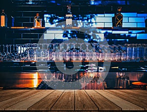 Wooden table in front of abstract blurred restaurant lights background of bar