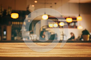 wooden table in front of abstract blurred restaurant lights background