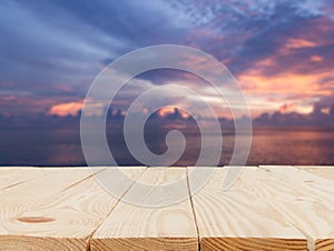wooden table in front of abstract blurred in view of the light sunset over the sea background
