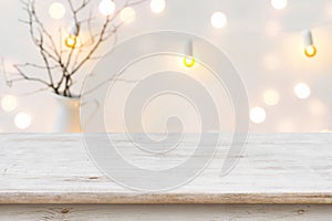 Wooden table in front of blurred abstract winter holiday background