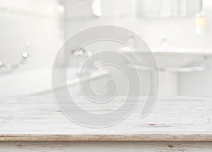 Wooden table in front of blurred bathroom interior as background