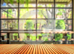 Wooden table in front of blurred coffee shop background