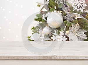 Wooden table in front of blurred decorated Christmas tree background