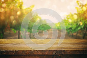 Wooden table in front of blurred vineyard landscape