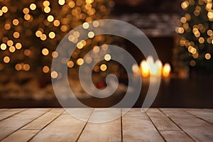 Wooden table in front of fireplace and christmas tree. Blurred background