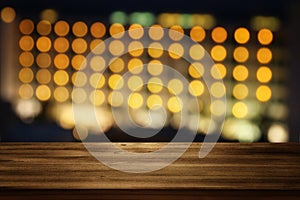 wooden table in front of night bokeh hotel. Ready for product display montages