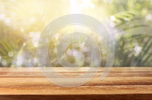 wooden table in front of tropical green floral background. for product display and presentation