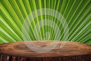 Wooden table in front of tropical green floral palm background. for product display and presentation.