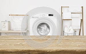 Wooden table in front of washing machine loaded with laundry