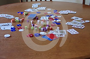 Wooden table full of dice, cards and poker chips