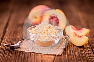 Wooden table with Ground Peaches, selective focus