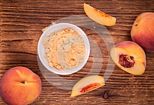 Wooden table with Ground Peaches, selective focus