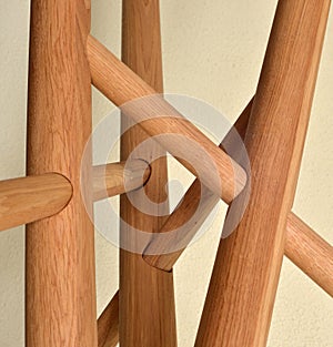 Wooden table legs isolated over gray background, close view photo, crossed star shaped legs, wooden eco furniture elements. Solid