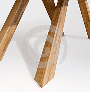 Wooden table legs isolated over white background, close view photo, crossed star shaped legs, wooden eco furniture elements