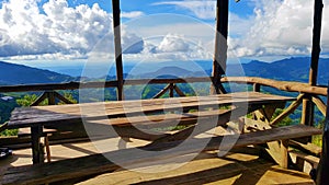 Wooden table in the mountain viewpoint with blue sky and cloud