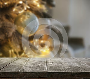 Wooden table near beautifully decorated Christmas tree. Space for design