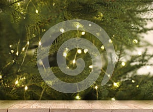 Wooden table near beautifully decorated Christmas tree. Space for design