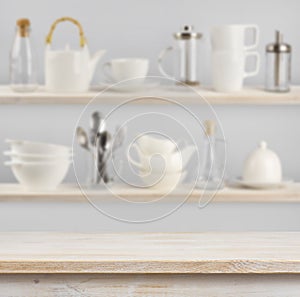 Wooden table over background of shelves with kitchen utensils