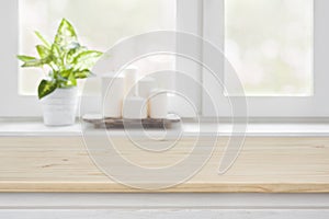 Wooden table over blurred window sill background for product display