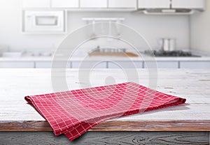 Wooden table with red napkin closeup. Kitchen background