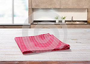 Wooden table with red napkin. Kitchen background