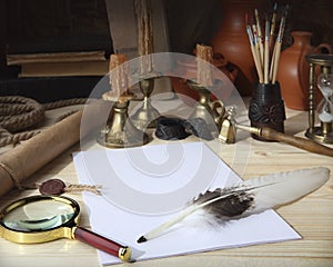 On the wooden table are: a scroll with a seal, sheets of white paper, a goose feather, an inkwell, tassels, a magnifying glass, b