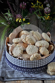 On a wooden table, small round biscuits with sesame seeds