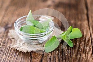 Wooden table with Stevia leaves (selective focus)