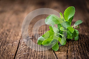 Wooden table with Stevia leaves (selective focus)