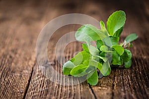 Wooden table with Stevia leaves (selective focus) photo