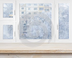 Wooden table surface over frosty window background