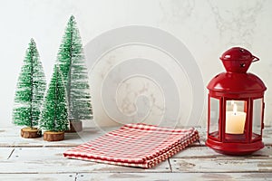 Wooden table with tablecloth and lantern over marble wall background.  Christmas and New Year mock up for design and product