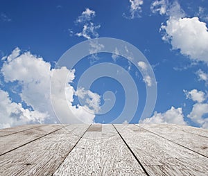 Wooden table top on blue sky with cloud