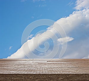 Wooden table top on blue sky with cloud