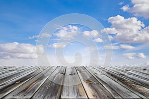 Wooden table top with blue sky and white clouds. Space for present a product