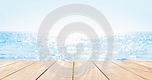 Wooden table top on blue summer sparking sea water with bokeh light