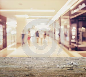 Wooden table top with blur of department store with bokeh background.