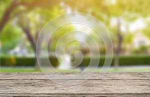 Wooden table top on blur green forest or garden with ray light and tree shadow.Fresh and Relax concept.perspective view.For