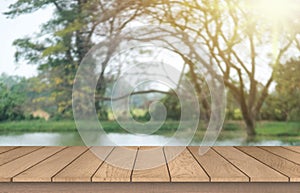 Wooden table top on blur green forest or gardent.Fresh and Relax concept.For montage product display or design key visual layout.