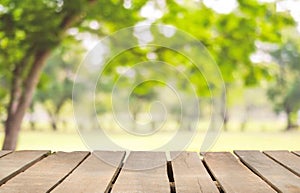 Wooden table top on blur green garden in the park or house village.For montage product display or design key visual layout.view of