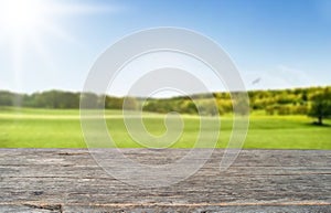 Wooden table top on blur mountain and grass field background in morning or evening atmosphere.For montage product display or