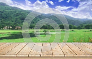 Wooden table top on blur mountain,grass field and blue sky.Fresh and Relax concept.For montage product display or design key