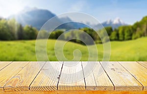 Wooden table top on blur mountain and grass field.Fresh and Relax concept.For montage product display or design key visual layout.
