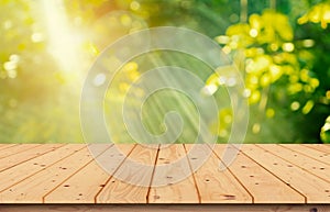 The wooden table top is blurred. The garden in the morning is used with the light of the sun for editing the product image or