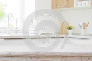 Wooden table top on blurred modern kitchen sink interior background