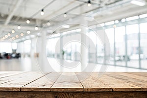 Wooden table top with blurred office space