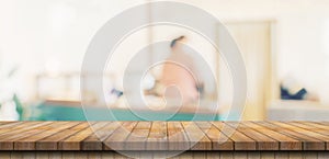 Wooden table top with blurred people in coffee shop and cafe background for display montage, copy space