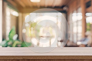 Wooden table top with blurred people in coffee shop and cafe background for display montage, copy space