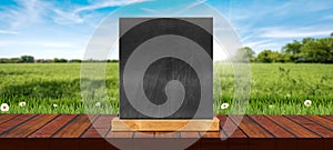 Wooden Table Top with Empty Blackboard on a Countryside Landscape