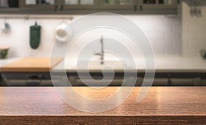 Wooden table top on kitchen island in front of blurred home interior.